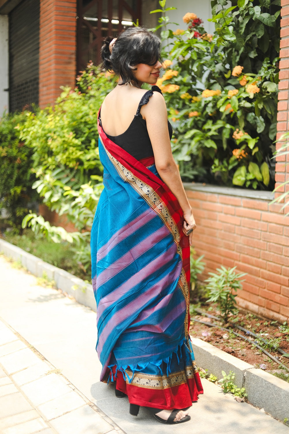 Woman in a blue narayanpet handloom cotton saree showing her pallu