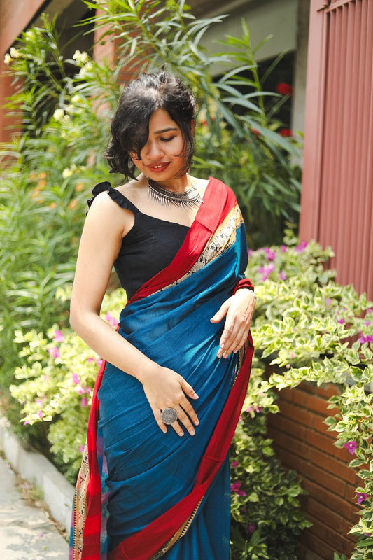 Woman in a blue narayanpet handloom cotton saree looking down