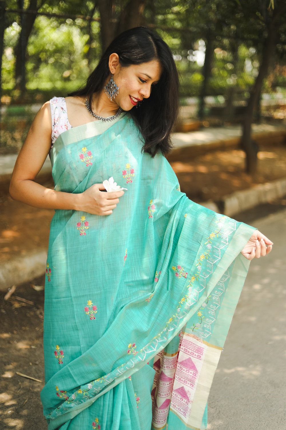 Blue linen cotton saree on a woman holding a flower