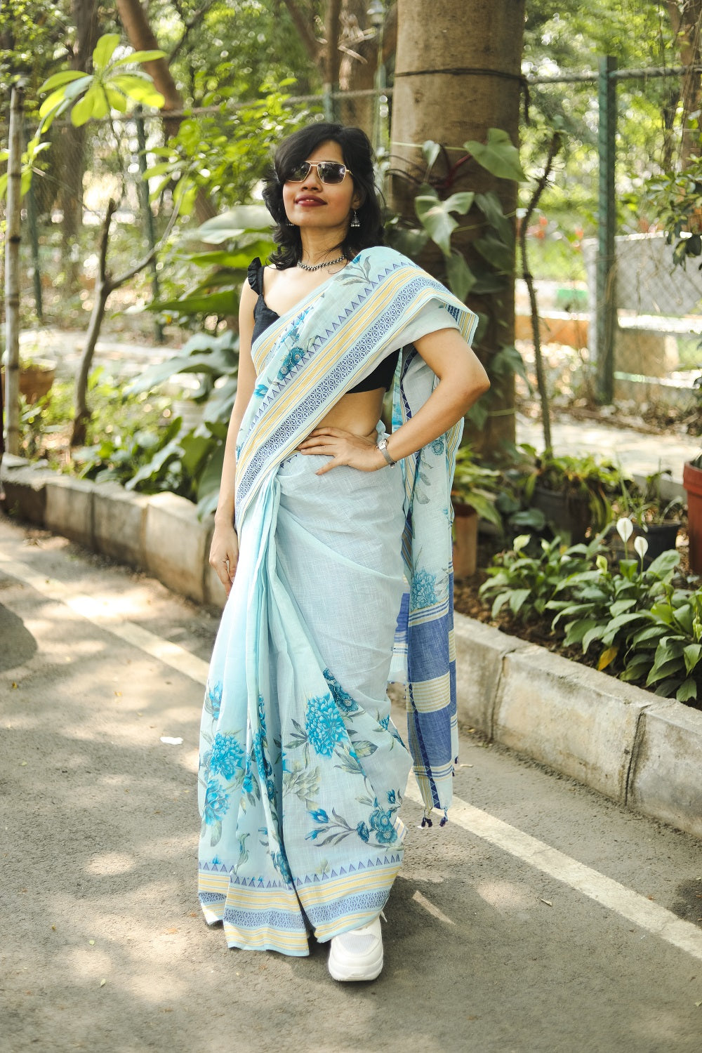 woman in a pastel blue khadi cotton floral printed saree in sunglasses