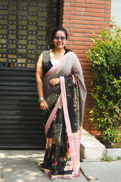 Woman in a saree against a brick wall and trees