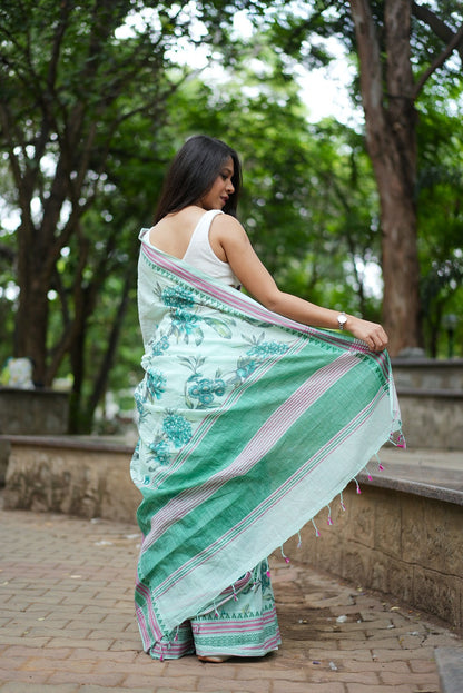 Woman in a pastel green floral printed khadi cotton saree from the back