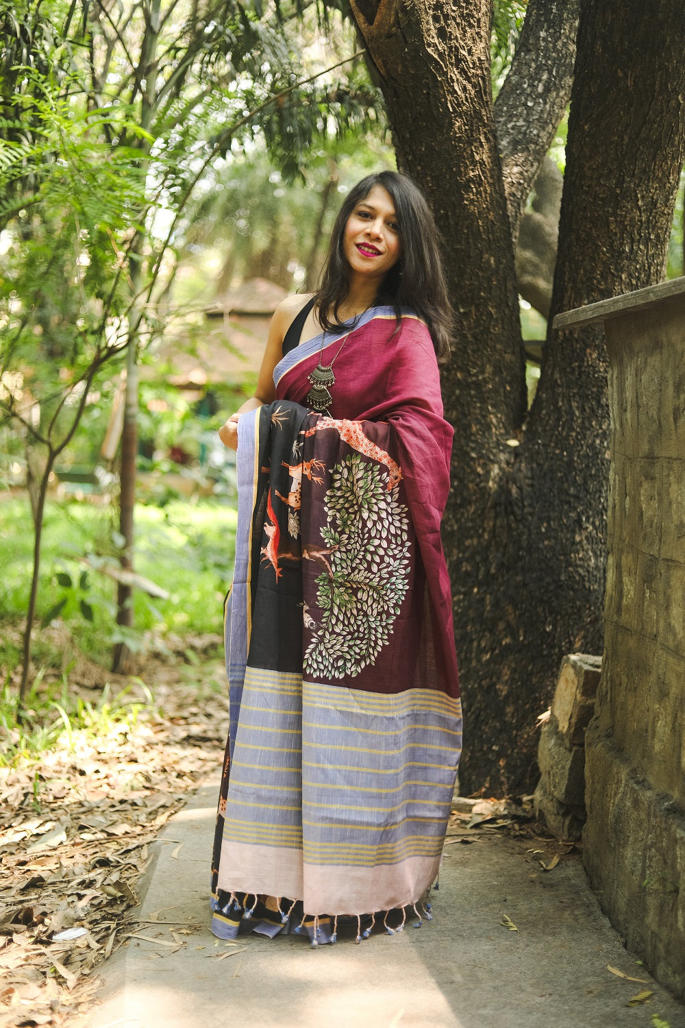 Woman in a park wearing a black saree