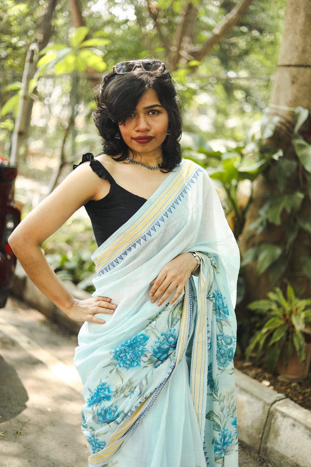 Woman in a pastel blue khadi cotton floral printed saree with her hand on the waist