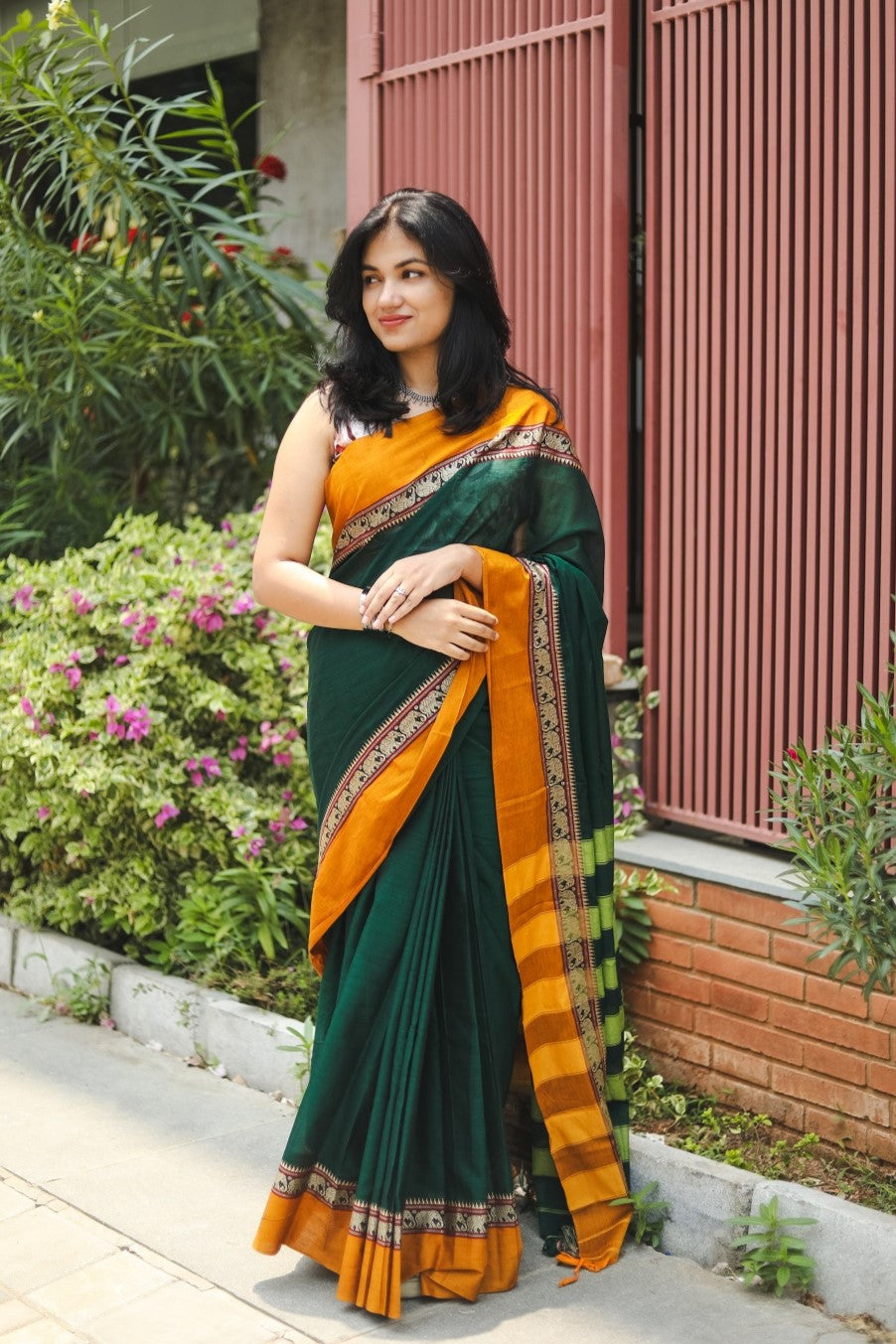 Woman in a green narayanpet handloom cotton saree posing