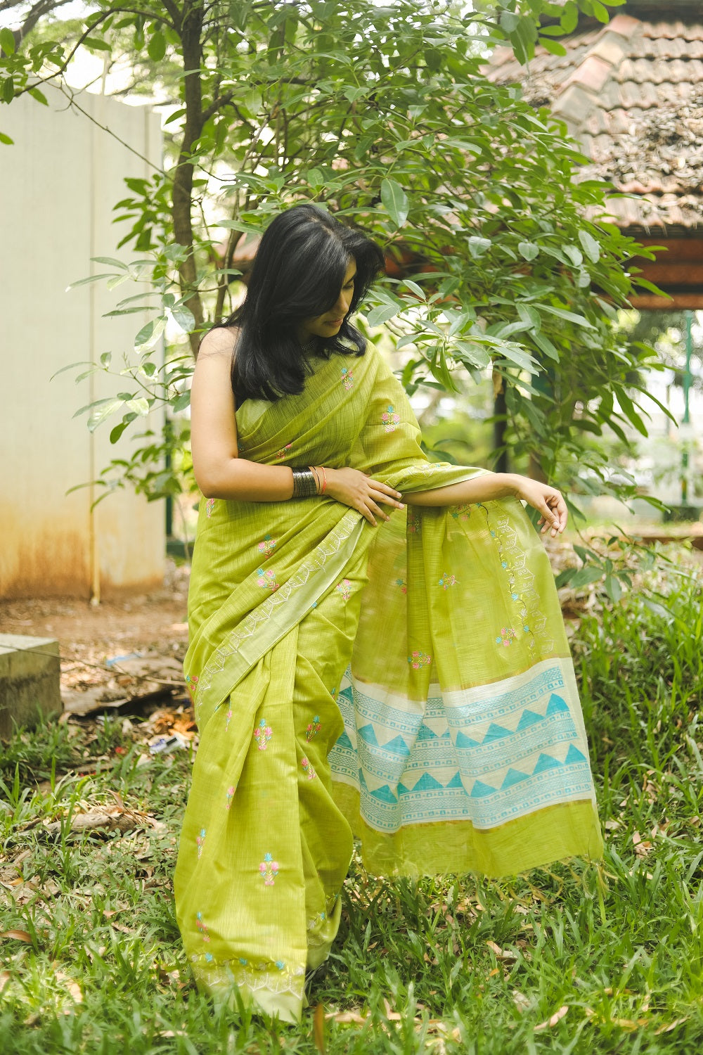 Woman in a vibrant green linen cotton saree showing her pallu