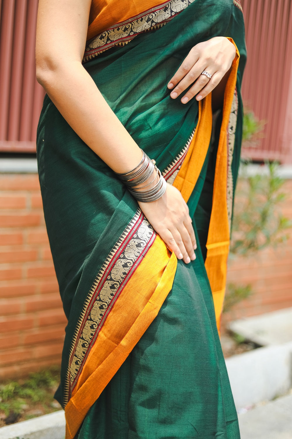 Woman in a green narayanpet handloom cotton saree half shot showing the details