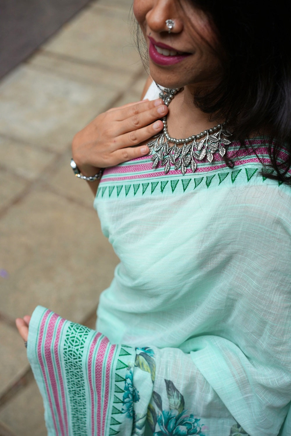 Top shot of woman in a pastel green floral printed khadi cotton saree with jewellery