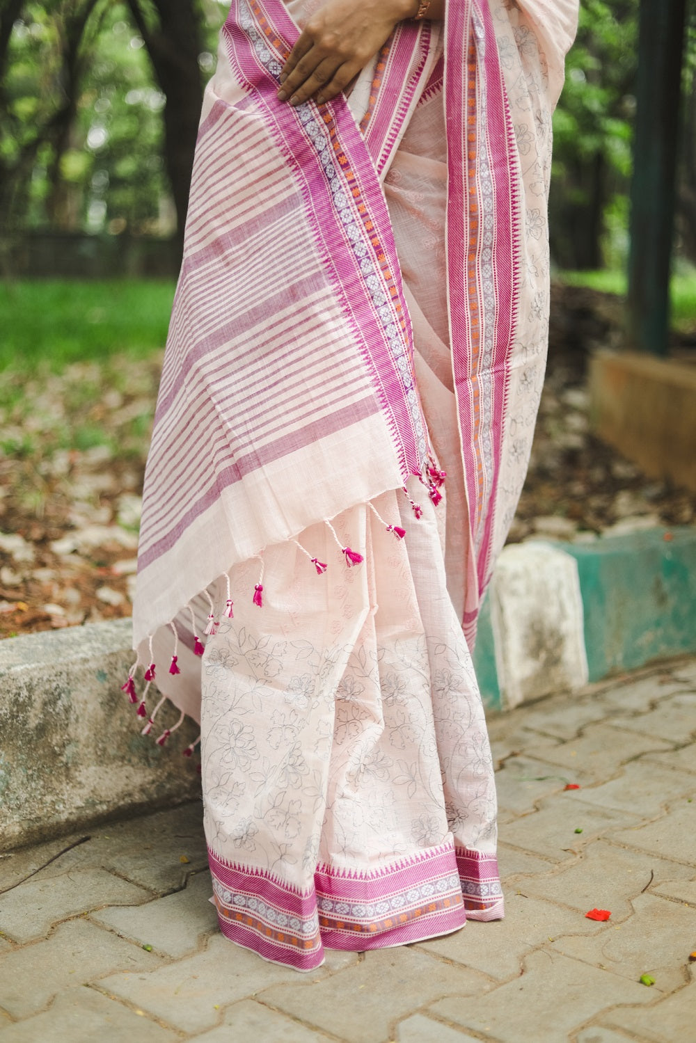 Woman in a pastel pink cotton sari showing the drape