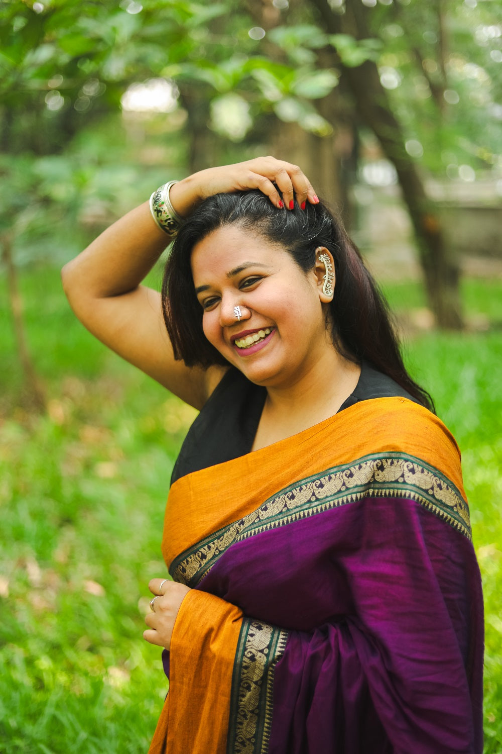 Woman wearing a purple narayanpet handloom cotton saree and smiling